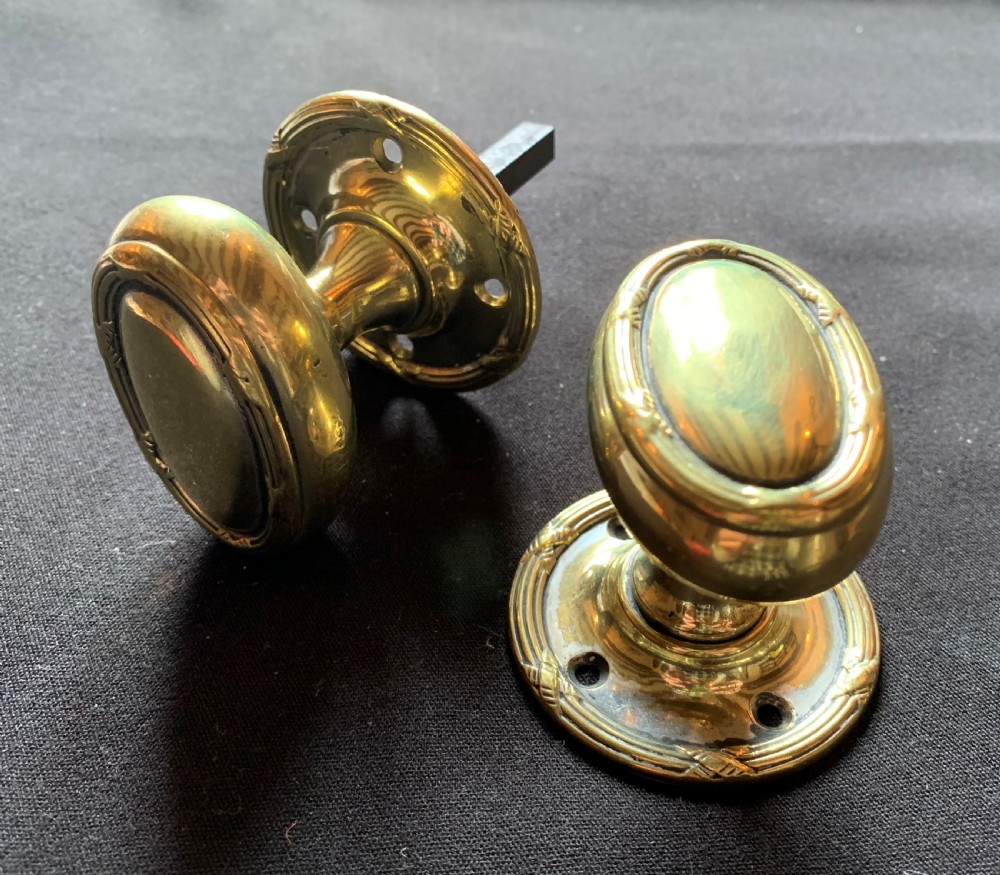one pair of brass regency oval door knobs