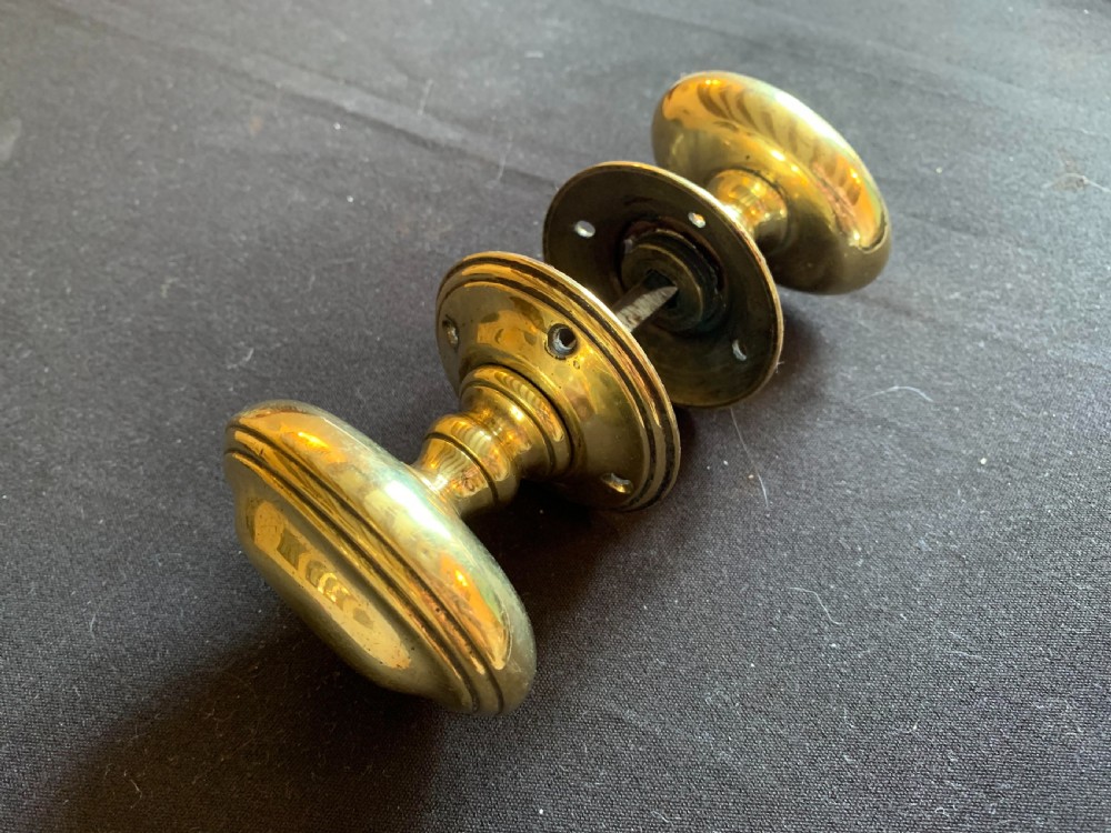 one pair of brass georgian ovular door knobs
